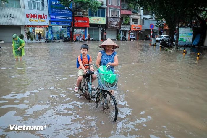 Cùng với cảnh chật vật trên đường là các phụ huynh phải vật lộn đưa con đi học trong đầu giờ sáng. (Ảnh: Hoài Nam/Vietnam+)