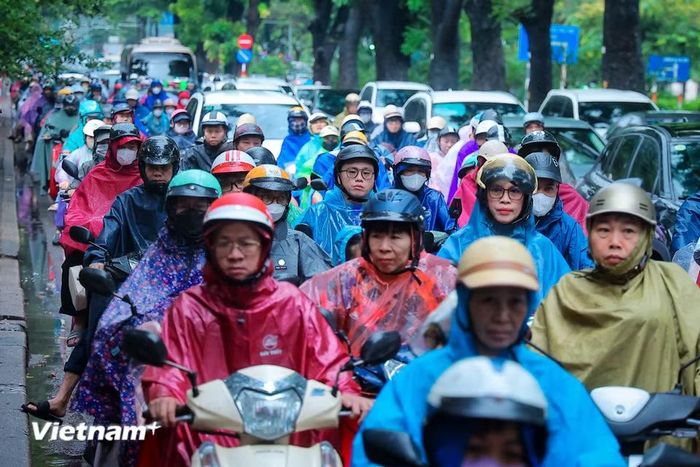 Cùng với đó, người dân cũng nhích từng centimet trên đường qua các con phố trong giờ cao điểm dưới trời mưa. (Ảnh: Hoài Nam/Vietnam+)