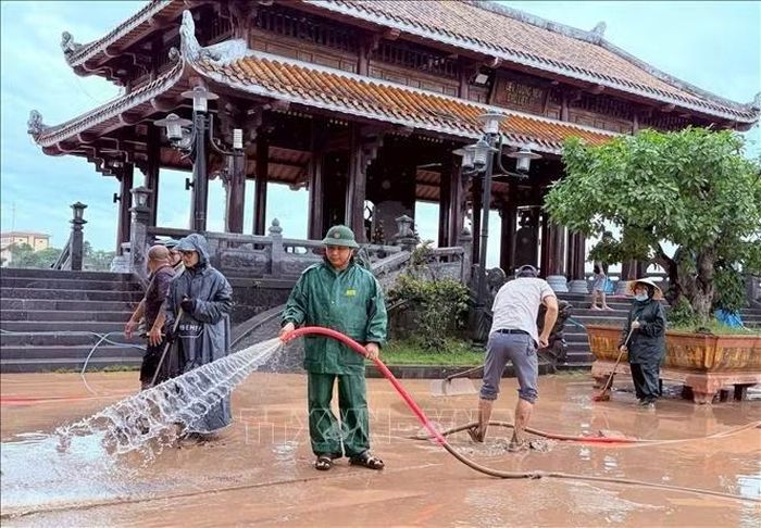 Cán bộ, viên chức, người lao động Trung tâm Dịch vụ Tổng hợp phường Quảng Trị tiến hành vệ sinh Bến thả hoa bờ Bắc sông Thạch Hãn. Ảnh: TTXVN phát