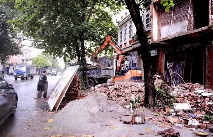 Một số nhà dân trên tuyến Quốc lộ 2 qua xã Vĩnh An đang được tháo dỡ, phục vụ công tác giải phóng mặt bằng dự án cải tạo, mở rộng tuyến. Ảnh: Hoàng Hùng/TTXVN