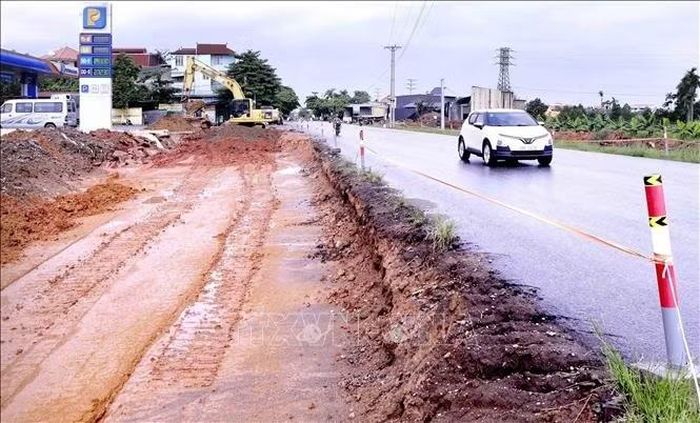 Đơn vị thi công tập trung đào, hạ nền đường phục vụ mở rộng Quốc lộ 2 qua địa bàn xã Vĩnh Hưng. Ảnh: Hoàng Hùng/TTXVN