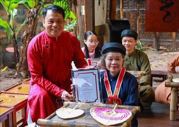 TS. Lê Xuân Kiêu - Giám đốc Trung tâm Hoạt động Văn hóa Khoa học Văn Miếu - Quốc Tử Giám trao chứng nhận cho những người thực hành thư pháp. Ảnh: Khánh Hòa/TTXVN