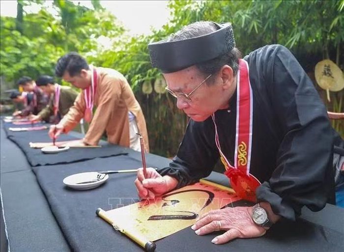 Nghệ nhân, người thực hành thư pháp trực tiếp thể hiện kỹ thuật và phong cách qua từng nét bút. Ảnh: Khánh Hòa/TTXVN