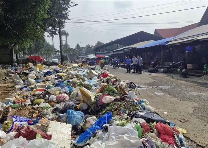Rác bủa vây 1 khu chợ ở đô thị Bảo Lộc khi Nhà máy xử lý rác của Công ty Cổ phần Môi trường Xanh Friendly tạm dừng tiếp nhận rác tại phường 1 do các bên còn vướng mắc về khối lượng, đơn giá, nghiệm thu, thanh toán. Ảnh: TTXVN phát