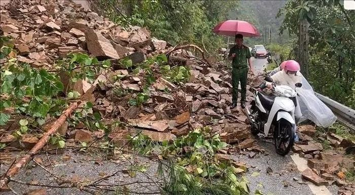 Mưa lớn gây sạt lở taluy dương và tắc đường tại Km265+900, Quốc lộ 32 thuộc địa phận xã Tú Lệ. Ảnh: TTXVN phát