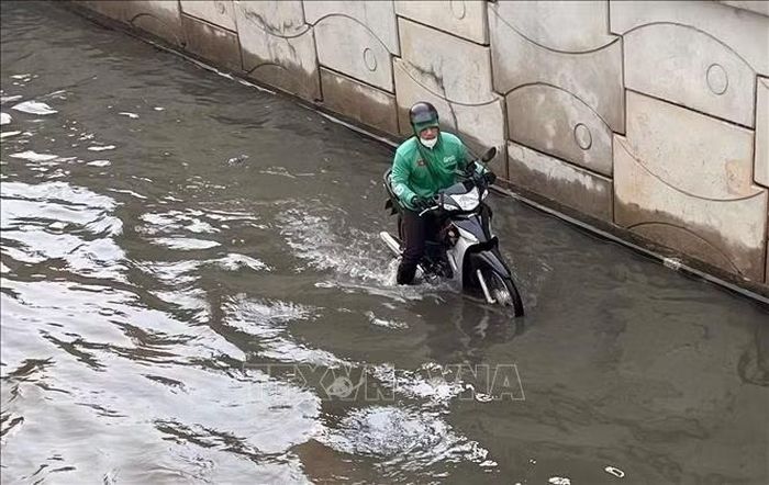 Đoạn ngập dài khoảng 100m, mực nước sâu từ 30 - 50cm. Ảnh: TTXVN phát