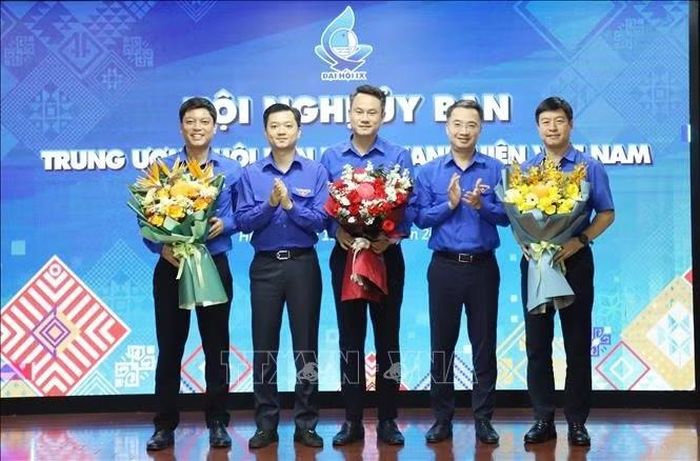 Chủ tịch Hội Liên hiệp Thanh niên Việt Nam khóa IX Nguyễn Kim Quy (giữa) cùng hai Phó Chủ tịch Lê Hải Long (ngoài cùng bên phải) và Đỗ Tuấn Hanh (ngoài cùng bên trái) nhận hoa chúc mừng từ lãnh đạo Trung ương Đoàn tại hội nghị.