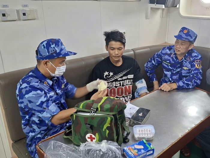 Quân y cấp thuốc, vật tư y tế và hướng dẫn cách chăm sóc vết thương cho ngư dân Danh Tiến trên tàu cá KG93028TS.