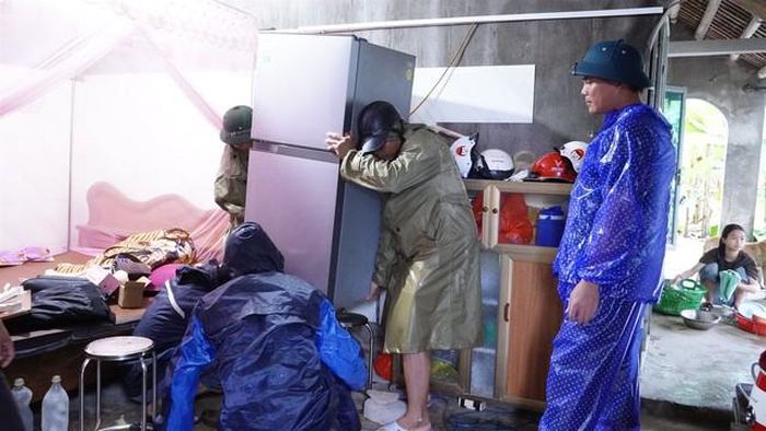 Lực lượng chức năng giúp người dân di dời tài sản đến nơi an toàn. (Ảnh: CTV)