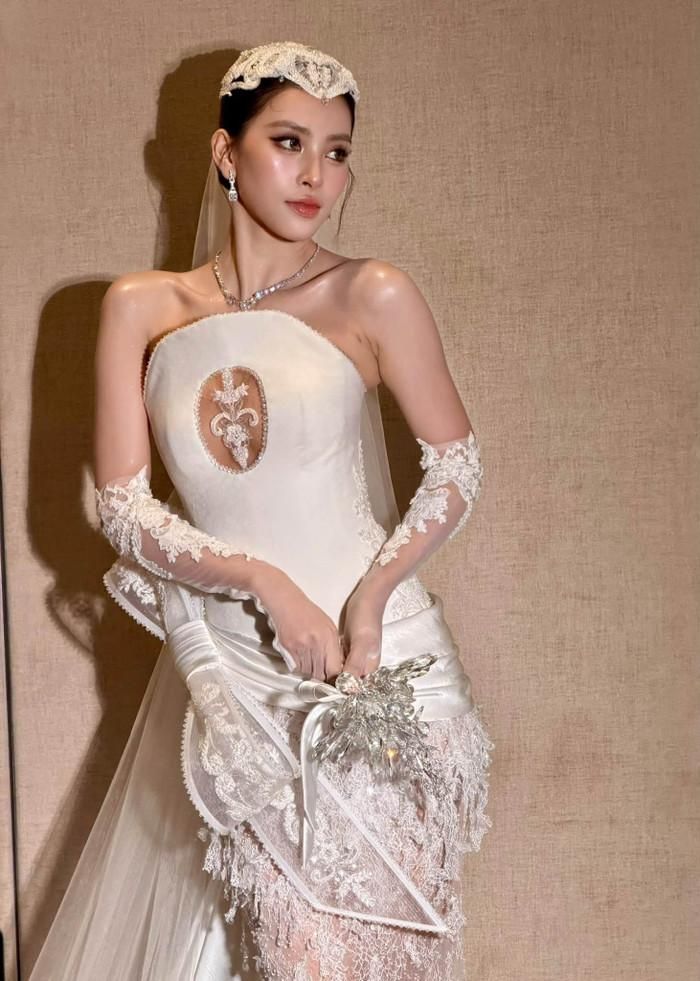 Tiểu Vy hóa cô dâu trong bộ váy cưới trắng, khoe nhan sắc thanh tú cùng thần thái sang trọng.