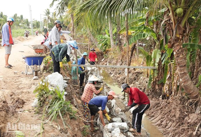 Công nhân xây kè đá dự án nâng cấp, mở rộng đường Mương Thầy Cai (đoạn từ đường Tôn Đức Thắng đến đường N1). Ảnh: THIỀU PHÚC