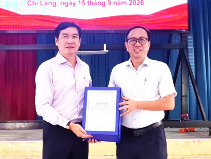 Phó Giám đốc Sở Xây dựng tỉnh An Giang Nguyễn Ngọc Vệ (bên phải) trao quyết định quy hoạch cho phường Chi Lăng. Ảnh: ĐỨC TOÀN