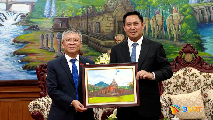 Bí thư Tỉnh ủy, Chủ tịch HĐND tỉnh Champasak Alounxay Sounnalath (bên phải) tặng bức ảnh lưu niệm cho đoàn công tác. Ảnh: HOÀN VŨ - VĂN HÙNG