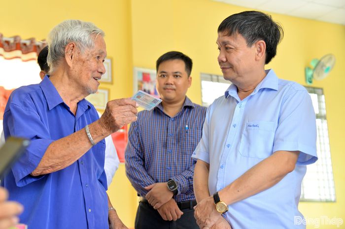 Đồng chí Phan Văn Thắng lắng nghe chia sẻ của người dân sau khi được hướng dẫn tích hợp Sổ sức khỏe điện tử trên ứng dụng VNeID.