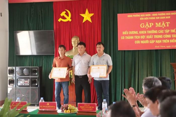 Ông Hoàng Châu Sơn - Chủ tịch UBND xã Núi Thành tặng giấy khen và quà cho đại diện 2 tàu cá BĐ-98960-TS và BĐ-98848-TS đã tham gia cứu tàu cá địa phương gặp nạn trên biển. Ảnh: H.L