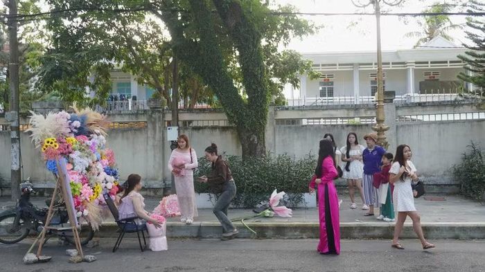  Người dân chờ đợi để chụp ảnh bên chiếc xe chở hoa mang tông màu của mùa thu. Ảnh: Chu Hằng 