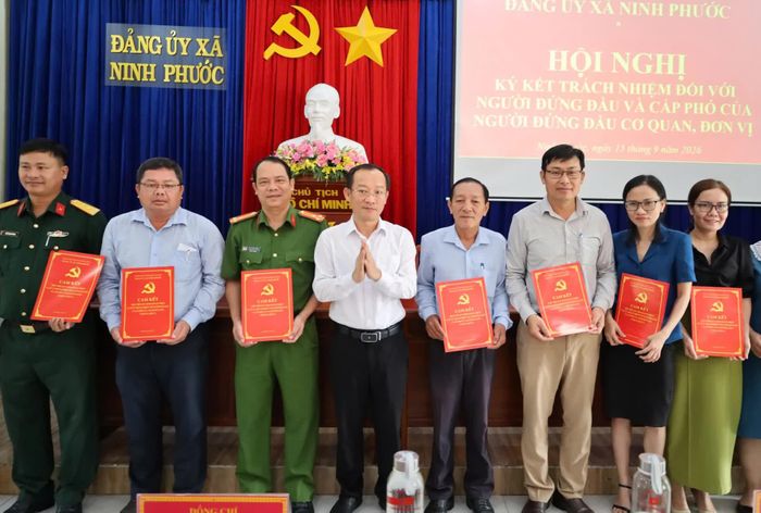Ông Nguyễn Hữu Tuấn - Bí thư Đảng ủy, Chủ tịch HĐND xã Ninh Phước trao bản cam kết cho người đứng đầu và cấp phó của người đứng đầu các cơ quan, đơn vị.