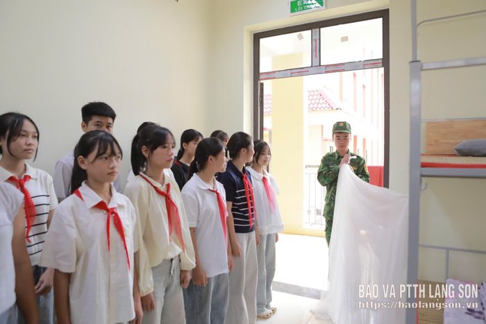Cán bộ, chiến sĩ Đồn Biên phòng Pò Mã hướng dẫn kỹ năng gấp chăn màn cho các em học sinh