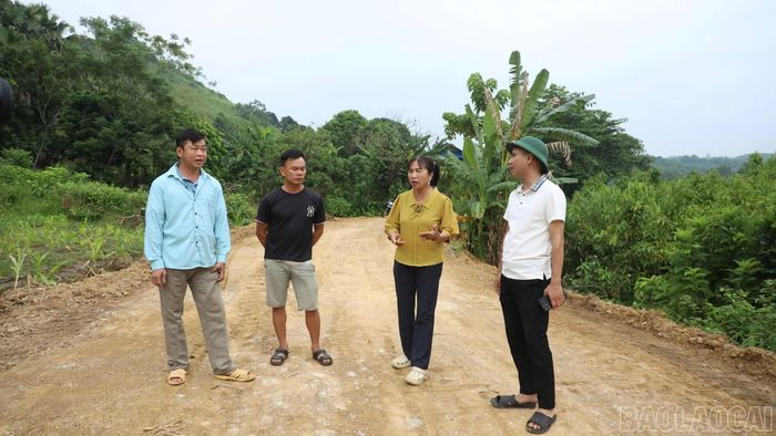 Bà Nguyễn Thị Mến trao đổi, vận động các hộ dân tham gia hiến đất làm đường.