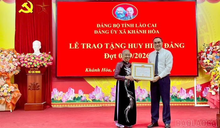 Đồng chí Nguyễn Hữu Long - Ủy viên Ban Chấp hành Đảng bộ tỉnh, Phó Bí thư chuyên trách Đảng ủy UBND tỉnh trao Huy hiệu 60 năm tuổi Đảng cho đảng viên Bùi Thị Lan.
