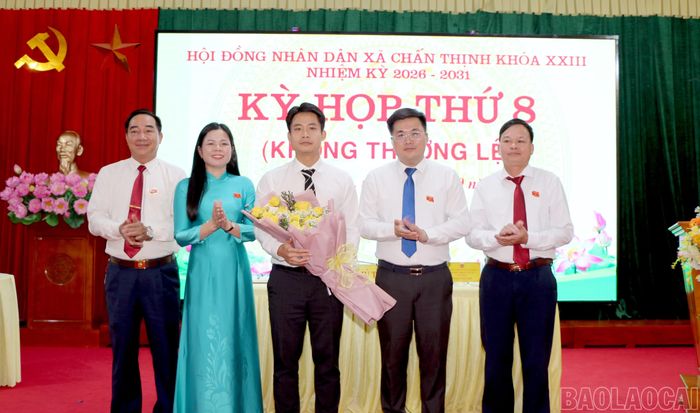 Các đồng chí lãnh đạo HĐND xã Chấn Thịnh tặng hoa chúc mừng tân Chủ tịch UBND xã Đồng Mạnh Linh.