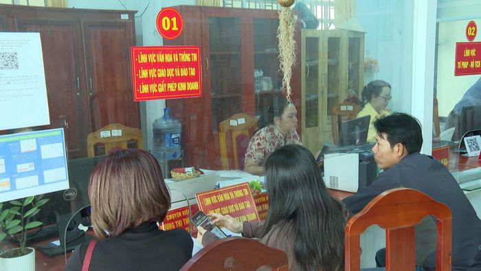 Người dân sử dụng điện thoại thực hiện giao dịch tại Trung tâm Phục vụ hành chính công xã Sơn Mỹ