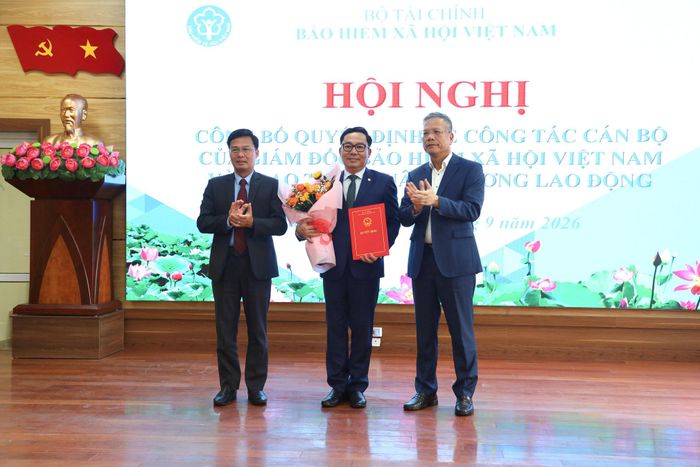 Phó Giám đốc BHXH Việt Nam Trần Đình Liệu và Tỉnh ủy viên, Phó Chủ tịch UBND tỉnh Lâm Đồng Đinh Văn Tuấn tặng hoa, trao quyết định điều động, bổ nhiệm ông Võ Khánh Bình giữ chức vụ Phó Giám đốc BHXH tỉnh Lâm Đồng