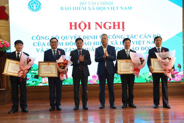 Phó Giám đốc BHXH Việt Nam Trần Đình Liệu và Tỉnh ủy viên, Phó Chủ tịch UBND tỉnh Lâm Đồng Đinh Văn Tuấn trao hoa, Huân chương Lao động của Chủ tịch nước cho các đồng chí lãnh đạo, nguyên lãnh đạo BHXH tỉnh