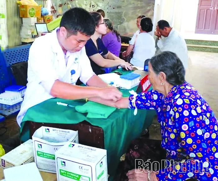 Nhân viên y tế lấy mẫu xét nghiệm khám sàng lọc sức khỏe miễn phí cho người dân thôn Liên Chung, xã Thu Cúc.