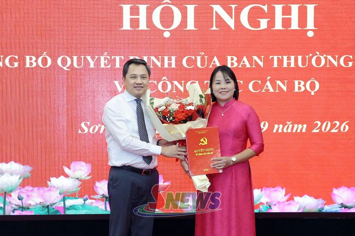 Đồng chí Chủ tịch UBND tỉnh trao quyết định và tặng hoa chúc mừng đồng chí Thào Thị Vàng.
