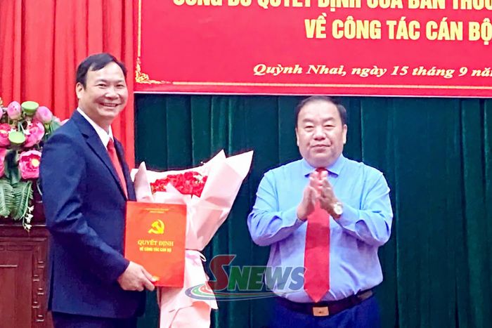 Đồng chí Chá A Của trao Quyết định và tặng hoa chúc mừng đồng chí Cầm Văn Huy.