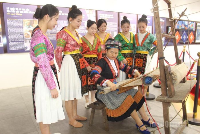 Nghệ nhân hướng dẫn du khách trải nghiệm dệt vải lanh truyền thống của đồng bào dân tộc Mông tại triển lãm “Sợi lanh kể chuyện văn hóa người Mông”.