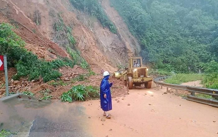 Đơn vị chức năng hót dọn đất đá tại một điểm sạt lở trên tuyến đường Hồ Chí Minh nhánh Tây ngày 13/9.