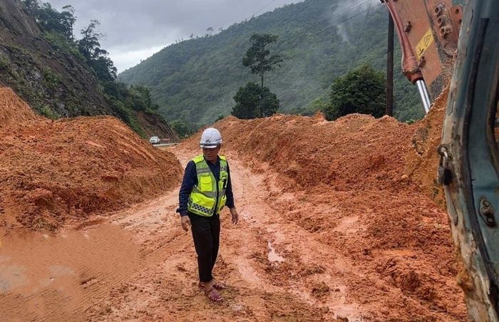 Hót dọn đất đá, thông xe trở lại đoạn đất đá từ phía ta luy dương sạt lở tràn xuống mặt đường gây ách tắc giao thông Km 204+500 đường Hồ Chí Minh nhánh Tây, ngày 14/9.