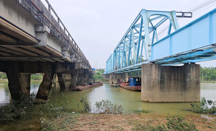 Chiếc sà lan thứ 3 (bên trái) cũng là chiếc sà lan cuối cùng trong số 3 chiếc sà lan bị trôi dạt mắc kẹt tại cầu Mỹ Chánh chuẩn bị được kéo về vị trí neo đậu an toàn phía hạ lưu cầu Mỹ Chánh.