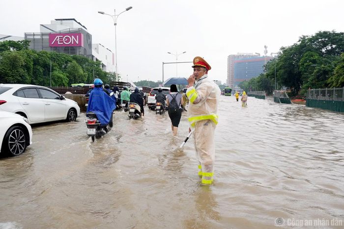 Đội CSGT số 5 (Phòng CSGT Công an TP Hà Nội) cử cán bộ, chiến sĩ ứng trực tại điểm úng ngập để đảm bảo giao thông, hướng dẫn phương tiện di chuyển an toàn.