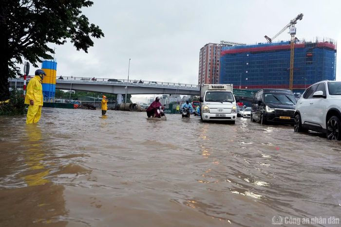 Công nhân của Công ty TNHH Một thành viên thoát nước Hà Nội đã ứng trực để hướng dẫn phương tiện vượt qua điểm ngập.