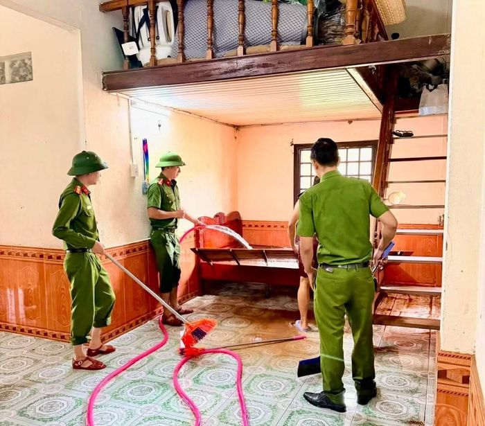 Lực lượng Công an giúp người dân Lao Bảo dọn dẹp nhà cửa, khắc phục bùn đất sau ngập lụt.