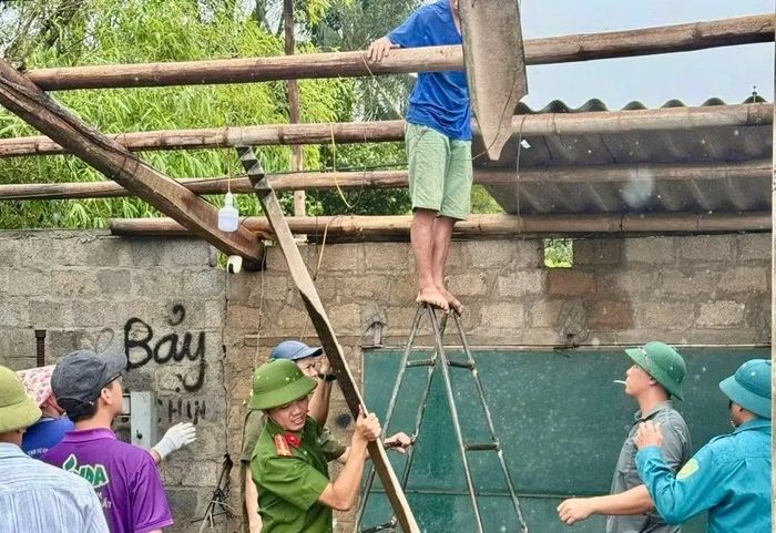 Công an xã Sen Ngư giúp người dân lợp lại mái nhà bị tốc do lốc xoáy.