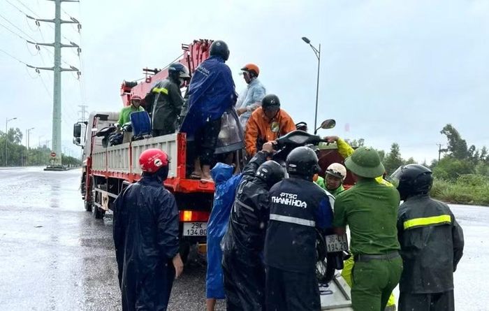Lực lượng Công an hỗ trợ người dân đi qua vùng bị ngập sâu.