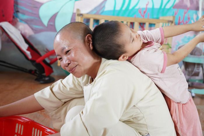 Một em bé nô đùa với sư cô Thích Đàm Ngoan.