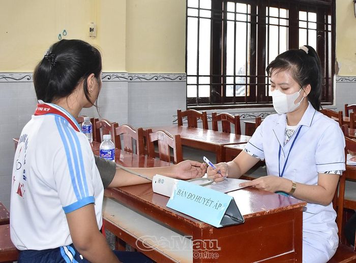 Cán bộ y tế, bác sĩ Trạm Y tế xã Định Thành khám sức khoẻ, sàng lọc cho người dân tại điểm khám lưu động ở Trung tâm Công ích xã.