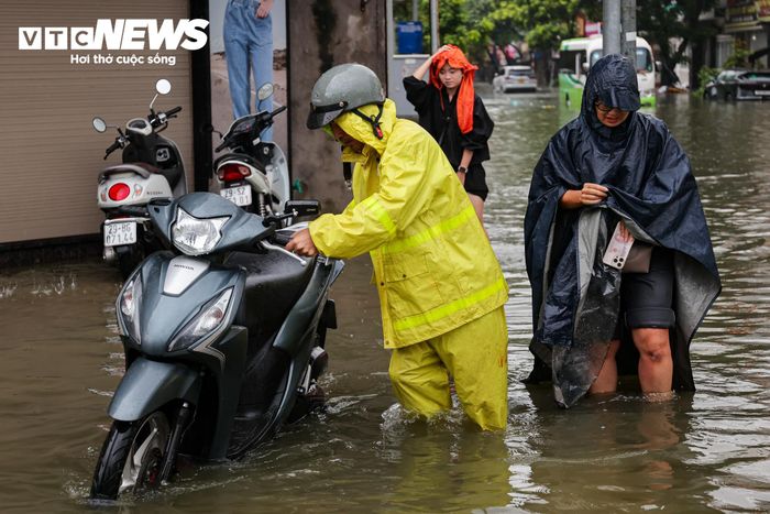 Có thời điểm, một số người đi xe máy bị ngã khi cố gắng vượt qua các đoạn nước sâu.