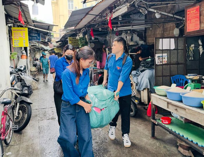 Đoàn Thanh niên hỗ trợ tiểu thương bốc dỡ, sắp xếp và vận chuyển hàng hóa, vật dụng ra khỏi khu vực chợ Kim Liên. Ảnh: PV