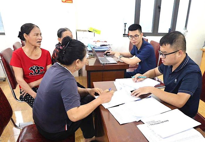 Người dân thôn Hậu Dưỡng ký hồ sơ xác nhận nguồn gốc sử dụng đất. Ảnh: PV