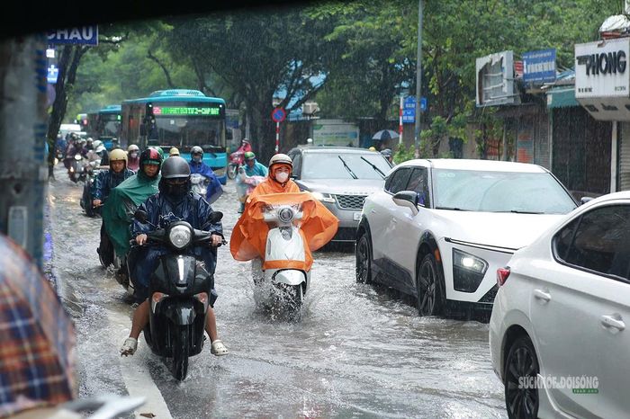 Ô tô, xe máy cùng chậm chạp vượt qua đoạn đường ngập nước. Ảnh: T.Anh