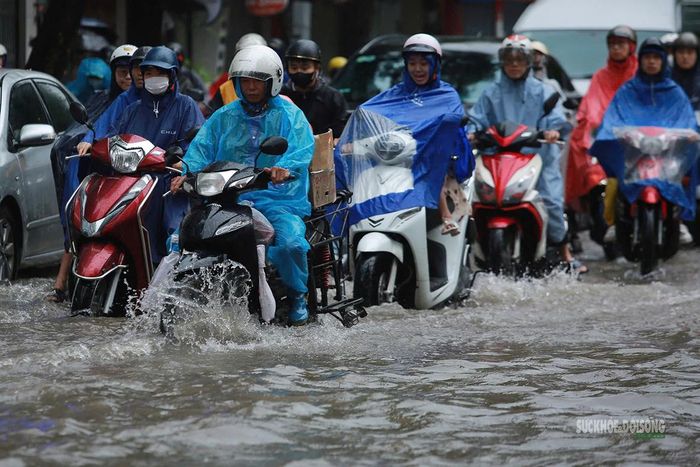 Nước phủ kín mặt đường, phương tiện phải lựa vị trí nông để di chuyển. Ảnh: T.Anh