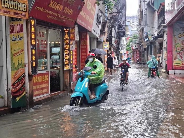 Một số đoạn ngập sâu, người dân điều khiển xe máy phải di chuyển chậm, né tránh những vị trí nước sâu.