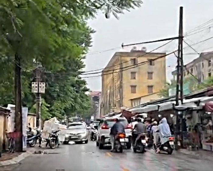 Tình trạng buôn bán trên vỉa hè, phương tiện dừng dưới lòng đường tại phố Lê Văn Hiến có thời điểm khiến giao thông qua khu vực bị ảnh hưởng, xảy ra ùn ứ. (Ảnh Thành Long)