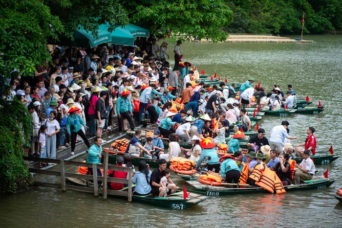  Du khách xếp hàng chờ đi thuyền tham quan Tràng An sáng 2/5. Ảnh: Đinh Hà.